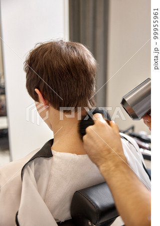 caucasian man getting haircut by professional male hairstylist 99955961