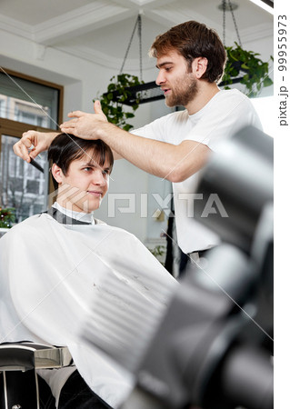 handsome young caucasian man visiting professional hairstylist handsome young caucasian man visiting professional hairstylist 99955973