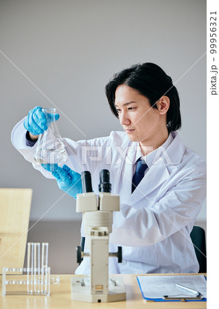 実験をする白衣の若い男性 99956321