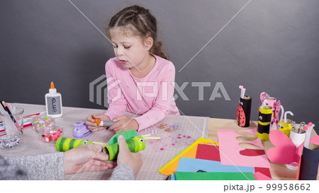 Kids papercraft. Making paper bugs out of the empty toilet paper rolls and construction paper. 99958662