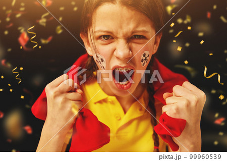Young girl emotionally watching football match, cheering up favorite team over dark background with confetti 99960539