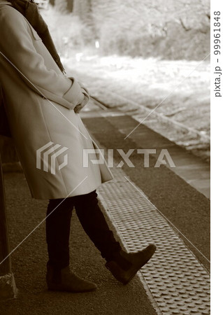 駅で寂しく待つ女性 99961848