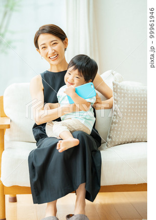 2歳の男の子とスマホで動画を見る母親 99961946