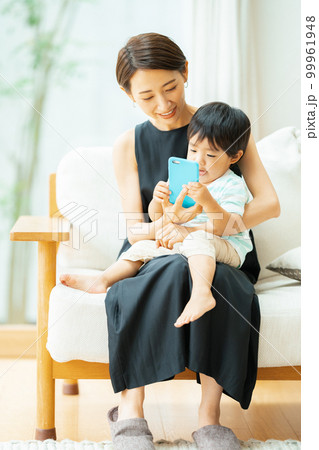 2歳の男の子とスマホで動画を見る母親 99961948
