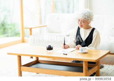 万年筆で手紙を書くシニア女性 99963058