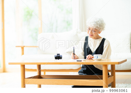 万年筆で手紙を書くシニア女性 99963061