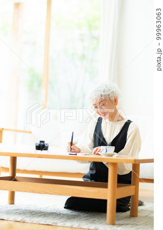 万年筆で手紙を書くシニア女性 99963063