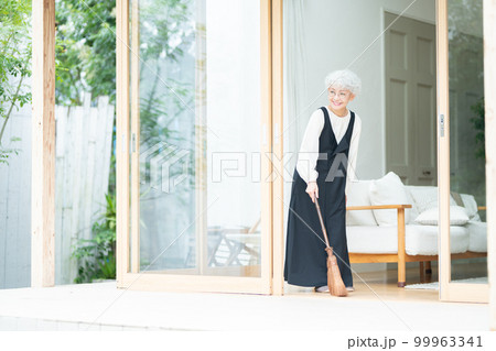 シュロ箒で掃除するシニア女性 シュロ箒で掃除するシニア女性 99963341
