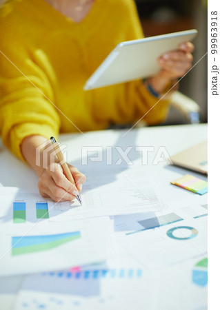 Business owner woman using tablet PC and working with documents Business owner woman using tablet PC and working with documents 99963918