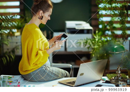 smiling elegant business owner woman in green office smiling elegant business owner woman in green office 99963919