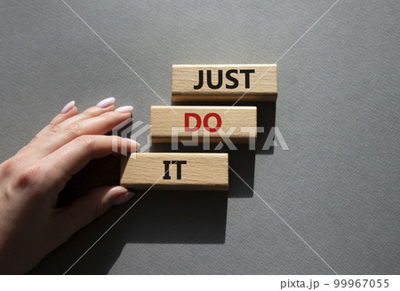 Just do it symbol. Wooden blocks with words Just do it. Beautiful grey background. Businessman hand. Business and Just do it concept. Copy space. Just do it symbol. Wooden blocks with words Just do it. Beautiful grey background. Businessman hand. Business and Just do it concept. Copy space. 99967055
