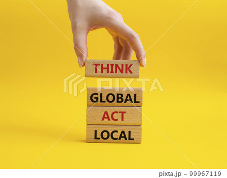 Think global act local symbol. Wooden blocks with words Think global act local. Beautiful yellow background. Businessman hand. Business and Think global act local concept. Copy space. 99967119