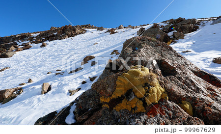 Snowy high mountains with bright sun and rocks. Snowy high mountains with bright sun and rocks. 99967629