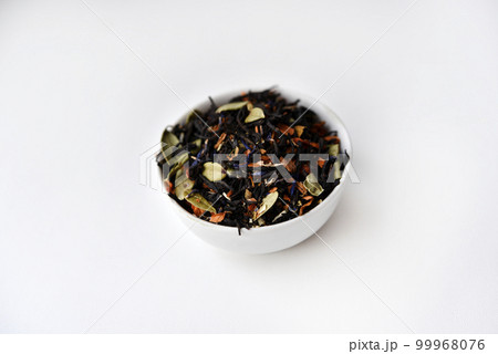 Black tea with spices in a glass cup on a white background. Delicious tea. Dry tea. 99968076