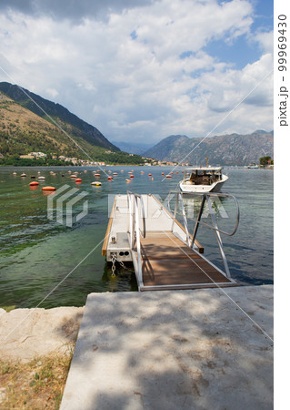 Very beautiful promenade of the Bay of Kotor, a small fishing boat. Montenegro. Beautiful and cozy city, Kotor embankment. The concept of rest and vacation in Europe. 99969430