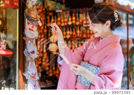 観光地で土産物を探す着物を着た若い女性 観光地で土産物を探す着物を着た若い女性 99972395