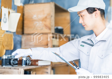 遺品の整理をする男性スタッフ 99983405
