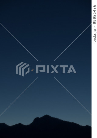 北杜市武川町、宵の空、甲斐駒ケ岳の上で接近する月齢1.8三日月と金星 99985436