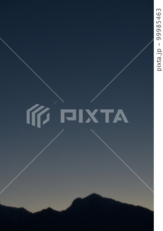 北杜市武川町、宵の空、甲斐駒ケ岳の上で接近する月齢1.8三日月と金星 99985463