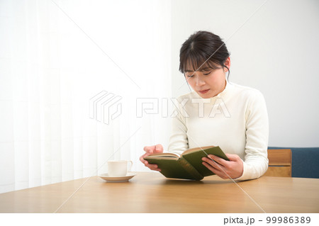 机で読書する女性 99986389