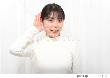 耳に手を当ててよく聞こうとする女性 耳に手を当ててよく聞こうとする女性 99986406