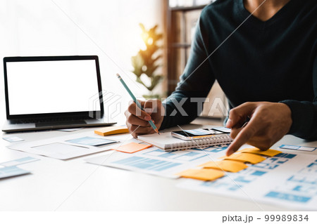 Website designer, Creative planning phone app development template layout framework wireframe design, User experience concept, Young asian man UX designer working on smartphone application at office. Website designer, Creative planning phone app development template layout framework wireframe design, User experience concept, Young asian man UX designer working on smartphone application at office. 99989834