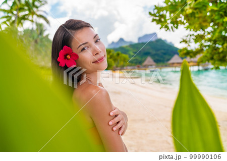 Spa Asian natural beauty woman wellness skin care, body and face care looking at camera serene outside at pardise beach on Bora Bora. Beautiful skincare concept with mixed race model girl Spa Asian natural beauty woman wellness skin care, body and face care looking at camera serene outside at pardise beach on Bora Bora. Beautiful skincare concept with mixed race model girl 99990106