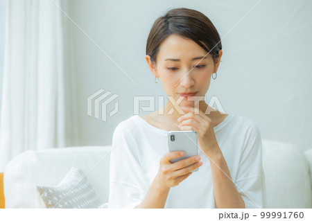 リビングの女性 スマホ リビングの女性 スマホ 99991760