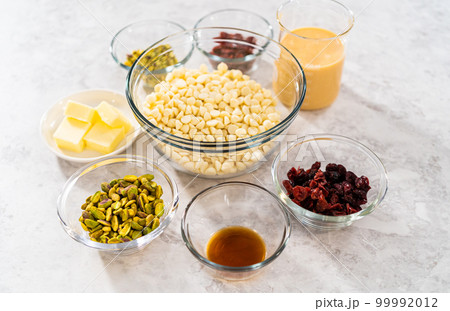 Measured ingredients in glass mixing bowls to prepare cranberry pistachio fudge. 99992012