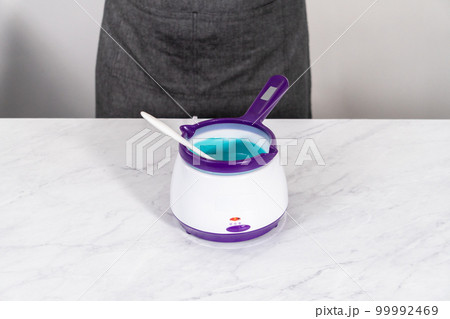 Melting chocolate melts in a candy melting pot to prepare mermaid cakesicles. Melting chocolate melts in a candy melting pot to prepare mermaid cakesicles. 99992469