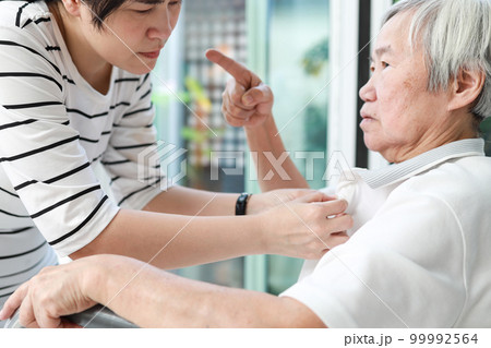 Angry asian senior grandmother scolding woman,Aggressive old elderly people shouting pointing finger at frightened female caregiver,dissatisfaction irritated,violence aggression,mental health concept 99992564