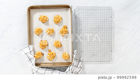 Flat lay. Cooling freshly baked white chocolate macadamia nut on a kitchen counter. Flat lay. Cooling freshly baked white chocolate macadamia nut on a kitchen counter. 99992599