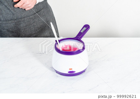 Melting pink chocolate melts to make mini pink chocolates. 99992621