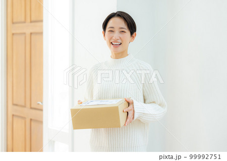 玄関で段ボールを持つ女性 玄関で段ボールを持つ女性 99992751