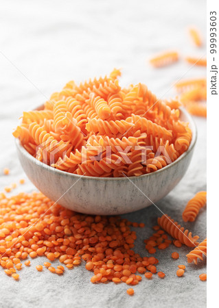Fusilli red lentil pasta on a gray textile background. Fusilli red lentil pasta on a gray textile background. 99993603