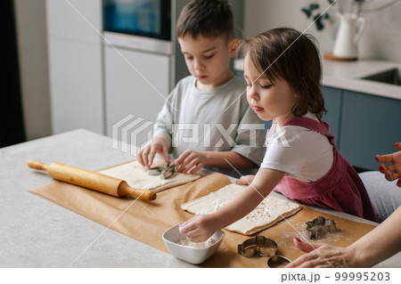 Siblings making cookies, preparing Easter. Siblings making cookies, preparing Easter. 99995203
