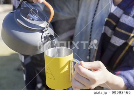 キャンプで沸かしたお湯を注ぐ若い女性手元 キャンプ女子 キャンプで沸かしたお湯を注ぐ若い女性手元 キャンプ女子 99998466