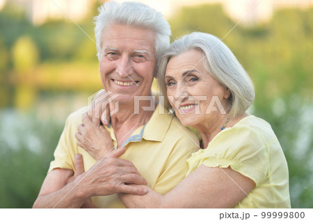 elderly couple walks in nature in summer elderly couple walks in nature in summer 99999800