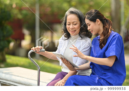 Caring female doctor explaining the medical results to senior woman while sitting on a bench in rehabilitation center park Caring female doctor explaining the medical results to senior woman while sitting on a bench in rehabilitation center park 99999938