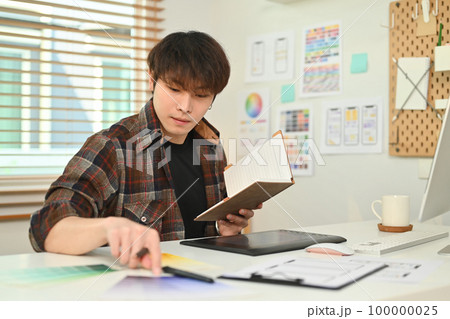 Young asian male designer planning mobile app development prototype wireframe design at creative office Young asian male designer planning mobile app development prototype wireframe design at creative office 100000025