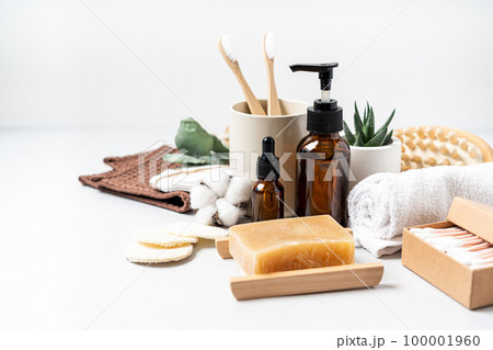 Natural bathroom and home spa tools. Zero waste sustainable lifestyle concept. Bamboo toothbrush, natural soap bar, cotton pads, homemade DIY beauty products in reusable bottles on white background 100001960