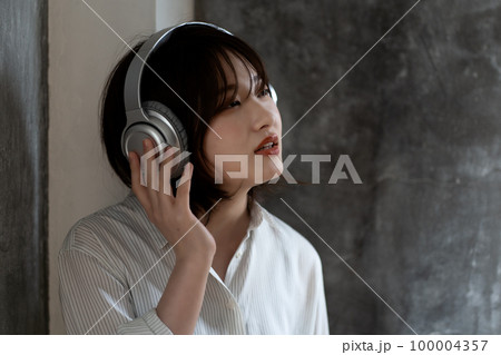 ヘッドフォンで音楽を聴くZ世代の女性 100004357