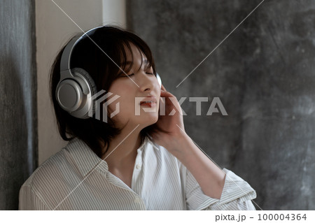 ヘッドフォンで音楽を聴くZ世代の女性 100004364