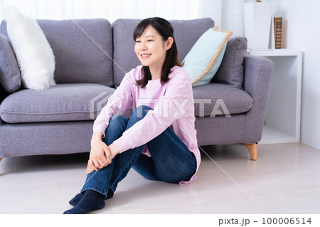 フローリングで寛ぐカジュアルな女性 100006514