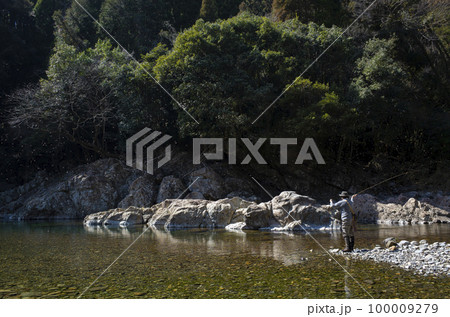 早春の川でフライフィッシングをする男性 100009279