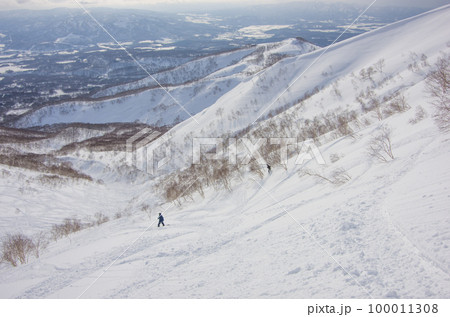 北海道虻田郡倶知安町のニセコアンヌプリのバックカントリーエリア鉱山の沢を滑るスノーボーダーとスキーヤ 100011308