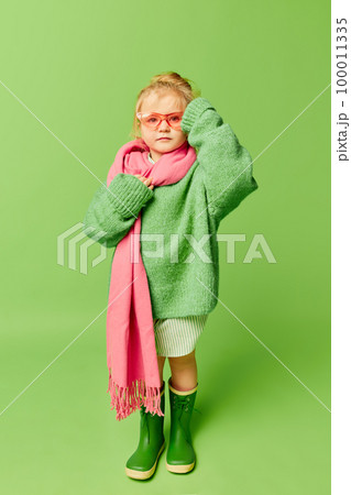Happy smiling cute kid, little girl in fashionable look clothes and sunglasses posing over light green background. Spring fashion collection, happiness, ad concept Happy smiling cute kid, little girl in fashionable look clothes and sunglasses posing over light green background. Spring fashion collection, happiness, ad concept 100011335