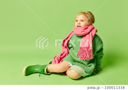 Happy smiling cute kid, little girl in fashionable look clothes and sunglasses posing over light green background. Spring fashion collection, happiness, ad concept 100011338