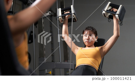 鏡を見ながら筋力トレーニングをする若い女性 鏡を見ながら筋力トレーニングをする若い女性 100011421