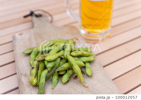 スキレットで枝豆のにんにく炒め料理と生ビール スキレットで枝豆のにんにく炒め料理と生ビール 100012057